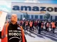 Figure1. Amazon workers protest algorithmic management and inhumane performance expectations outside a fulfilment centre in the UK. The slogan “We Are Not Robots” symbolises resistance against dehumanising workplace automation. (Image: GMB Union)